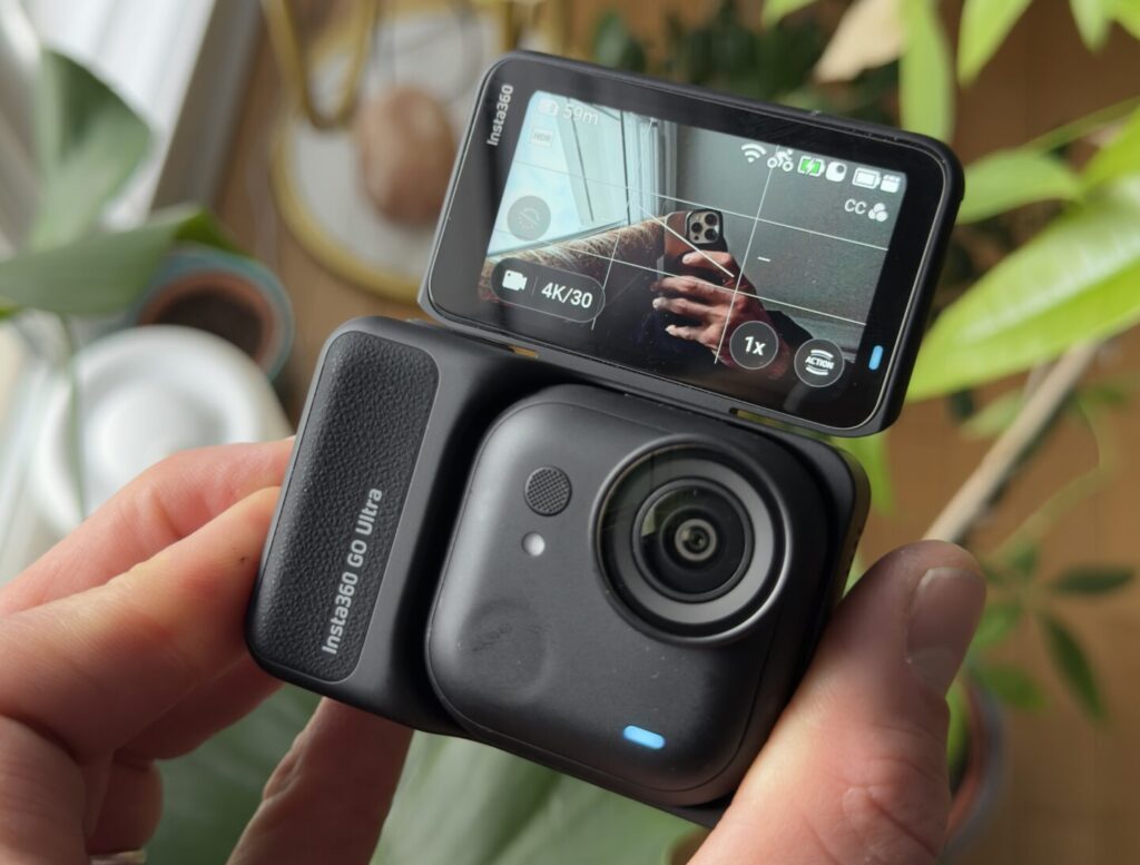 caméra Insta360 GO Ultra posée sur son boîtier avec écran rabattable ouvert